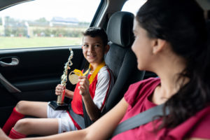 Boy showing his soccer mom the trophy he won in summer camp