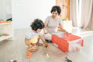 Mom and son putting the toys in the box.