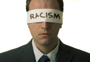 Blindfolded man with "racism" text on the blindfold