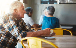 A worried senior in a coffee shop