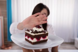 Woman refusing slice of cake