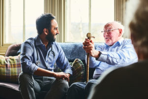Young doctor and old man have a casual chat on the couch.