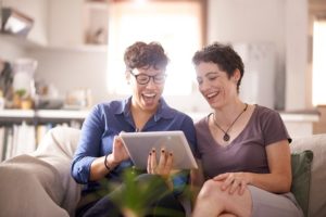 Couple sitting on couch looking at tablet together