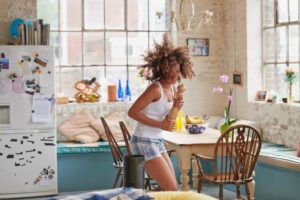 Woman, wearing pajamas, dancing alone at home