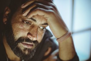 Man with sad expression and head resting in his hands