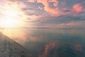 Beach with calm, smooth water at sunset