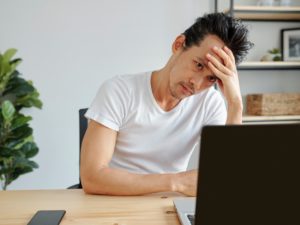 Tired man working on laptop
