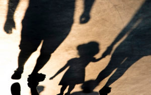 Shadows of parents holding child's hand