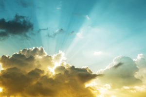 Rays of sunlight shining from behind a cloud