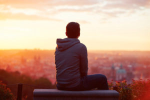 Man watching sunrise over a city