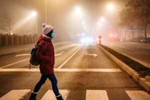 Woman wearing a mask crossing the street
