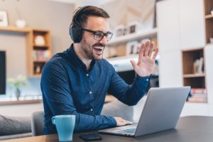 Man waving during online therapy session