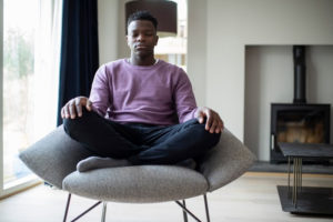 Man meditating in a chair at home