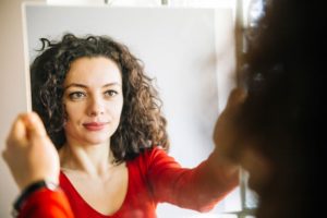 Woman looking at her reflection in a mirror