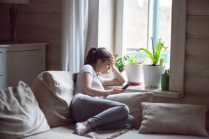 Young woman on her phone alone at home