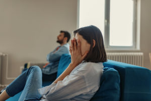 Frustrated couple on a couch at home.