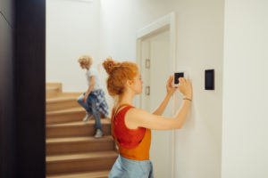 Woman adjusting thermostat