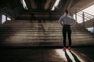 Woman standing before stairs.