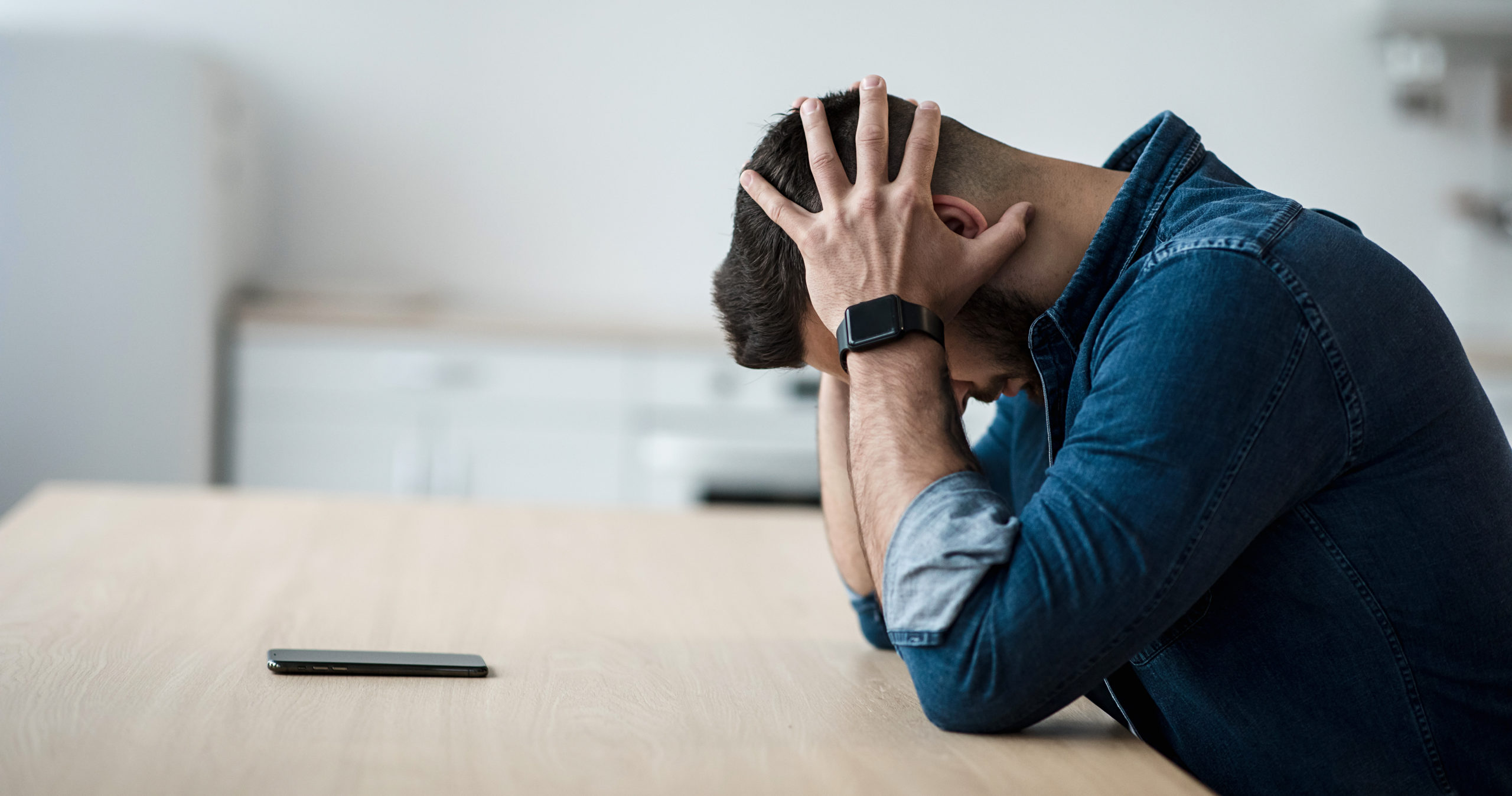 Man holding his Phone in Dark place sitting.