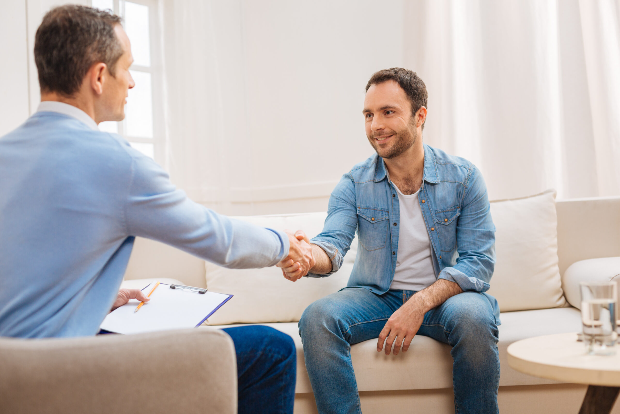 Male shaking hands with male therapist after a successful session