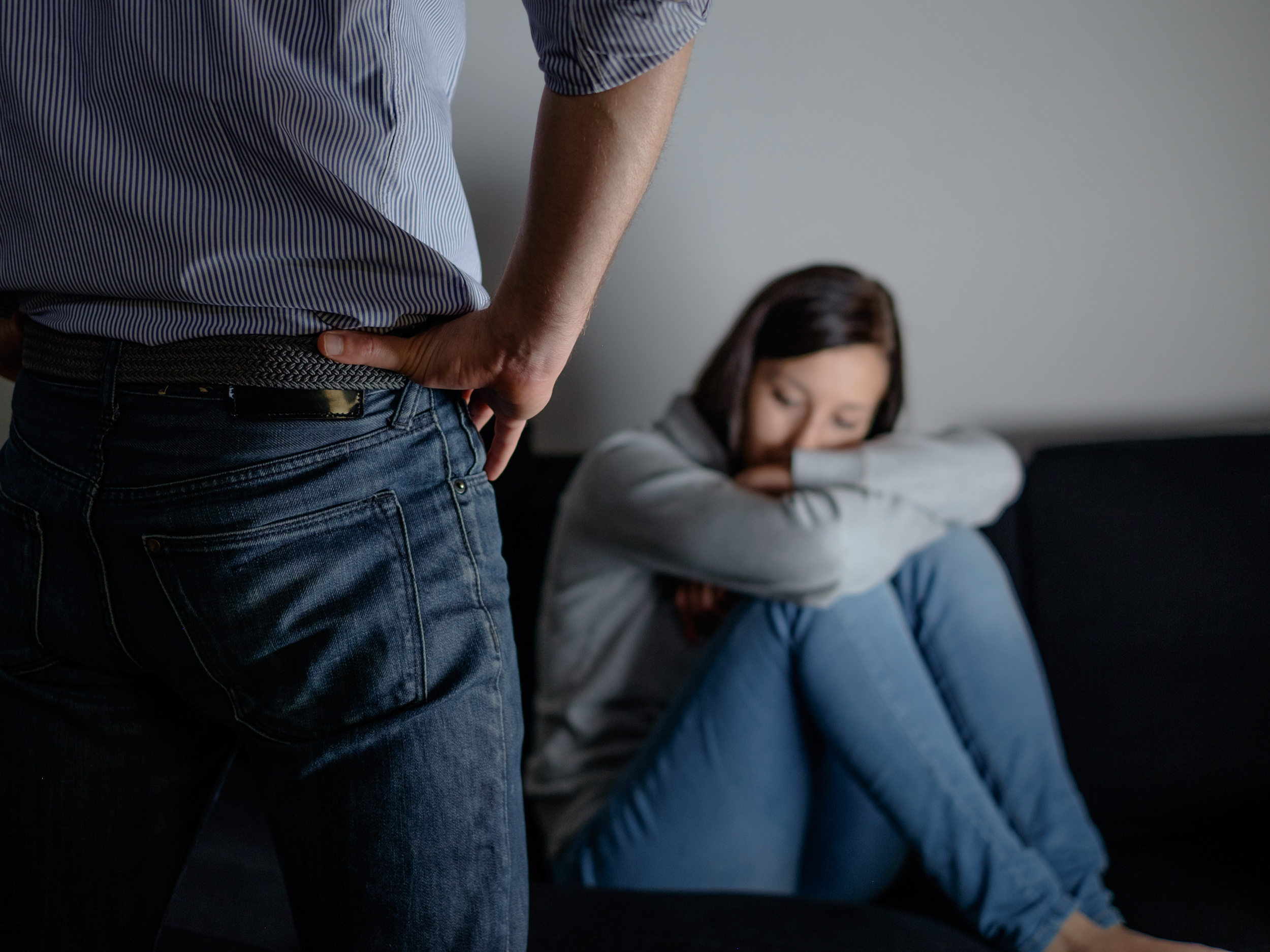 Man standing over woman who is scared