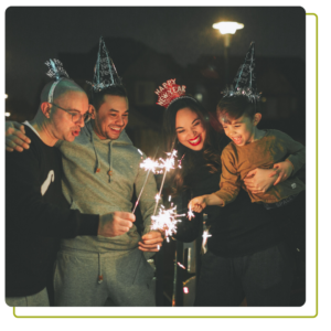 Uma família comemorando a véspera de Ano Novo com chapéus de festa e estrelinhas.