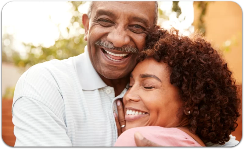 Movember: You Can Grow a Mustache, But Did You Have the Conversation? 1 Smiling older man hugging a woman closely during Movember.