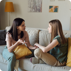 Mother having a sex talk with kids in a comfortable living room.