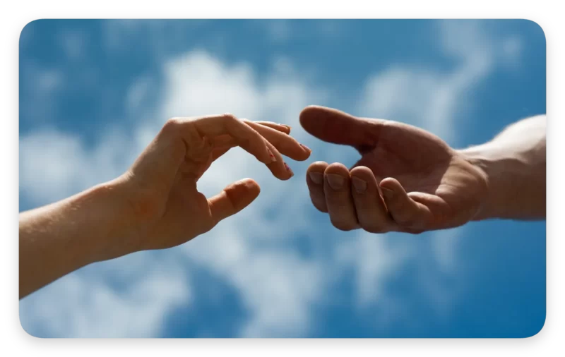 How Feeling Safe Heals Your Brain: 5 Ways Interpersonal Neurobiology Explains It 3 Two hands reaching towards each other against a blue sky, symbolizing human connection and the principles of interpersonal neurobiology.