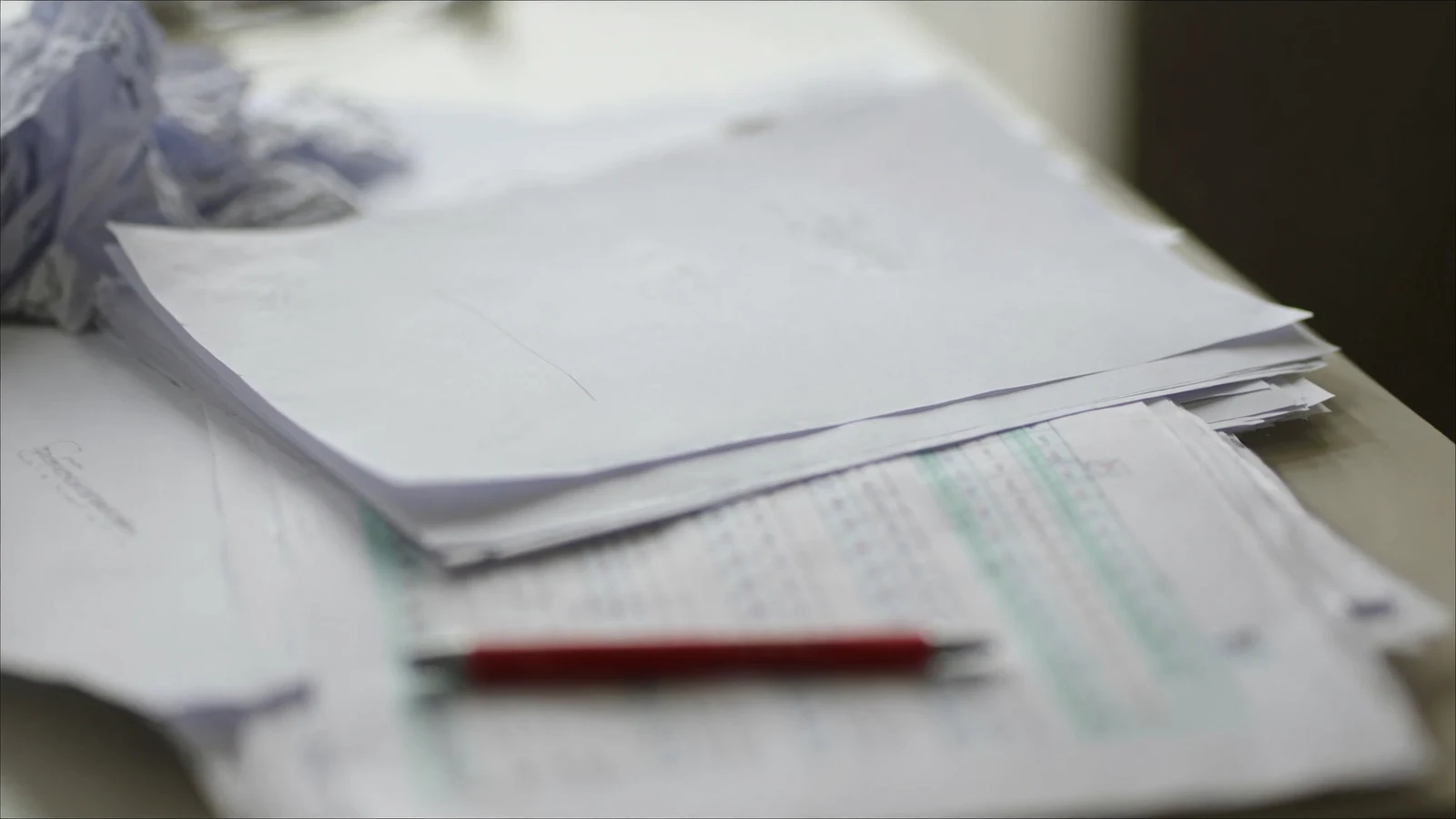 A stack of drafts and a red pen, suggesting the challenge of accepting good-enough work in perfectionism recovery