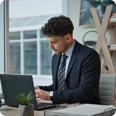 High achiever working at a laptop and reflecting on success and fulfillment