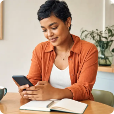 Person using Moodfit, a mood tracking app beside a journal