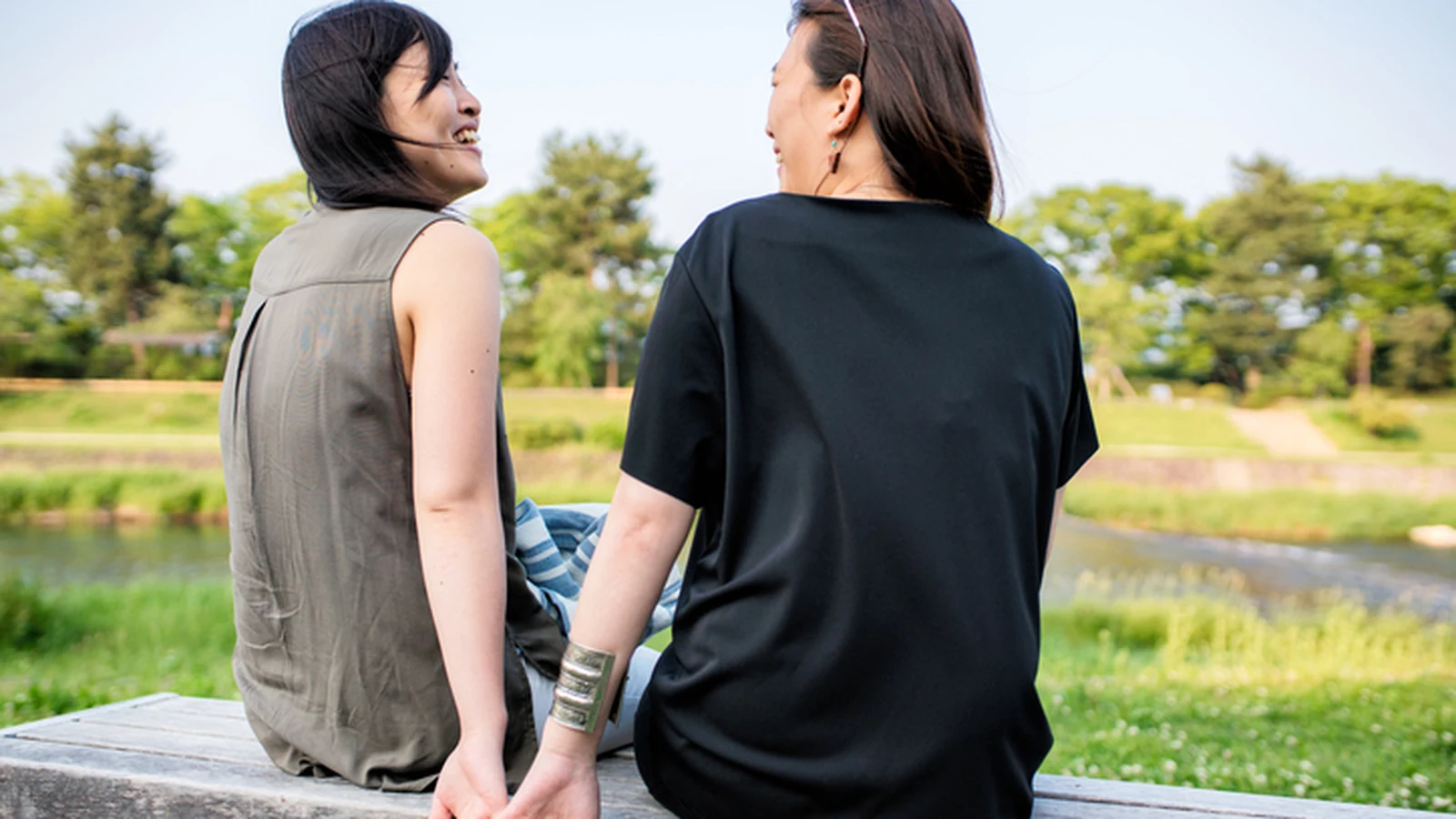 LGBTQ+ Affirming Therapy Is More Than Acceptance. Here’s Why 2 Two people sitting together outdoors in a supportive conversation for an article about LGBTQ+ affirming therapy.