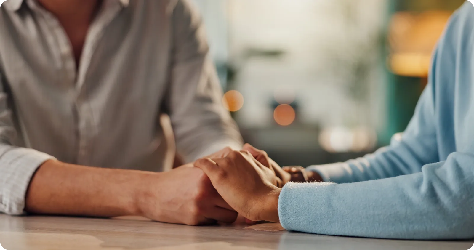 Perimenopause and Marriage: When Midlife Feels Like a Relationship Crisis 1 A couple holds hands at a table, showing support during perimenopause and marriage stress