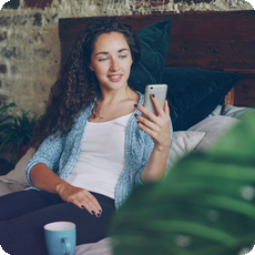 Person using a smartphone at home, representing cycle awareness and emotional self-care