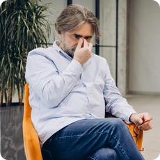 Rounded featured image of a person experiencing stress in a therapy office
