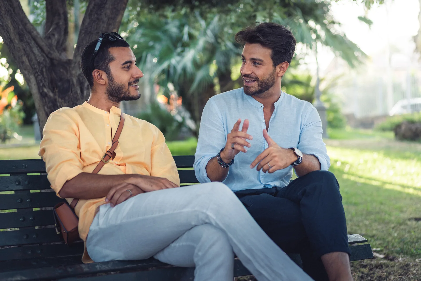 Two people talk together on a park bench.