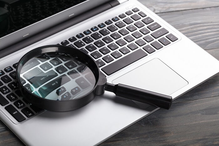 Magnifying glass sitting on laptop keyboard