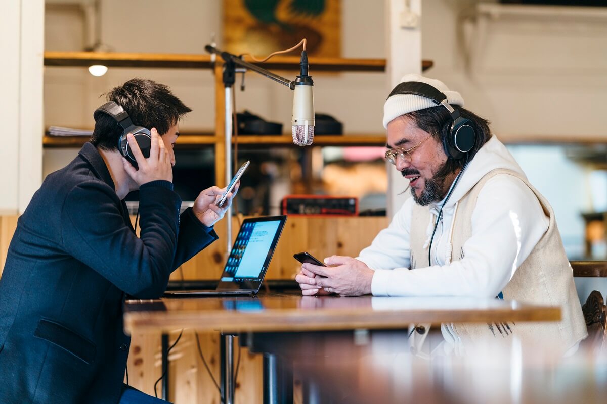 Two men in a recording studio make a podcast.