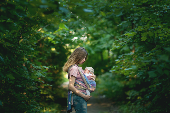 Mother holding baby in forest