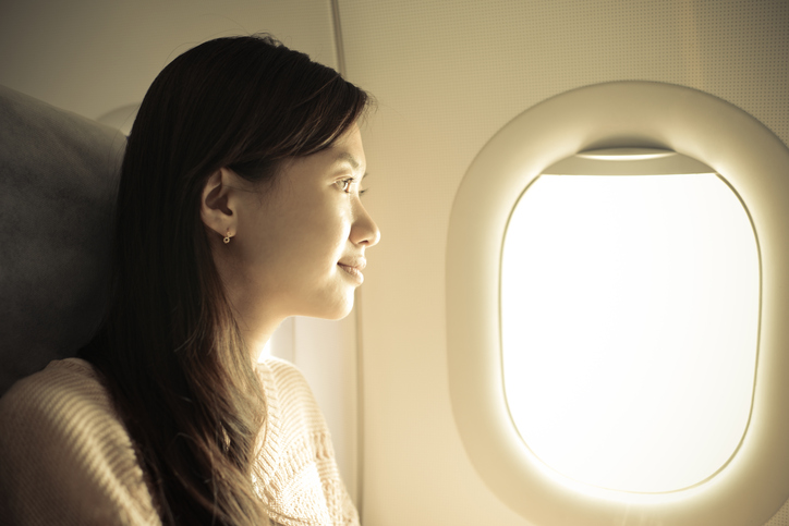 Woman sitting in airplane and looking out the window