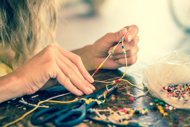 Focus on a woman's hands, working with beads