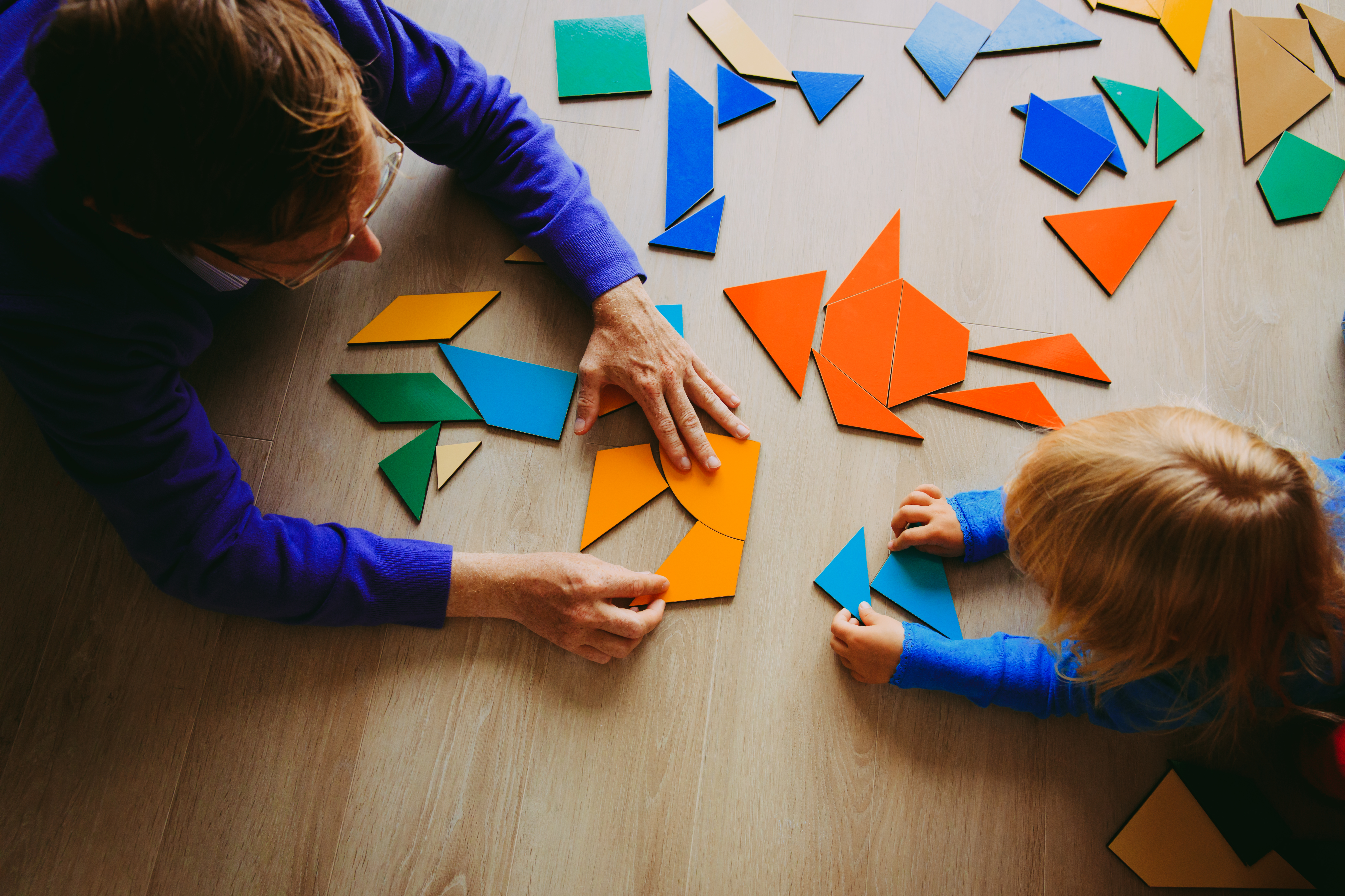 Woman and child playing with colorful shapes.