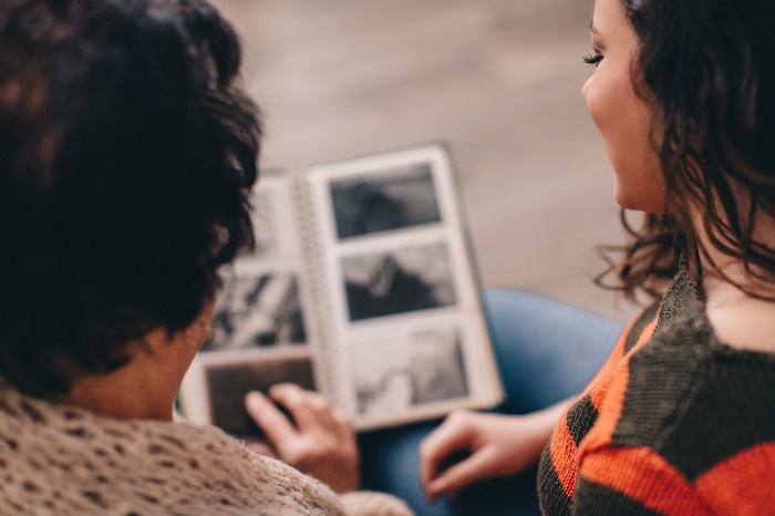 Grandmother and granddaughter looking at photographs from the past together.