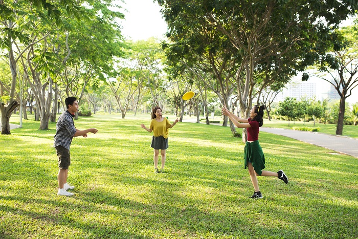 Three teens playing with a Frisbee in the park