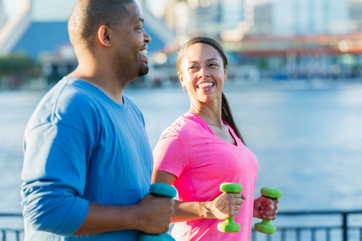 A couple gets some outdoor exercise along the river.