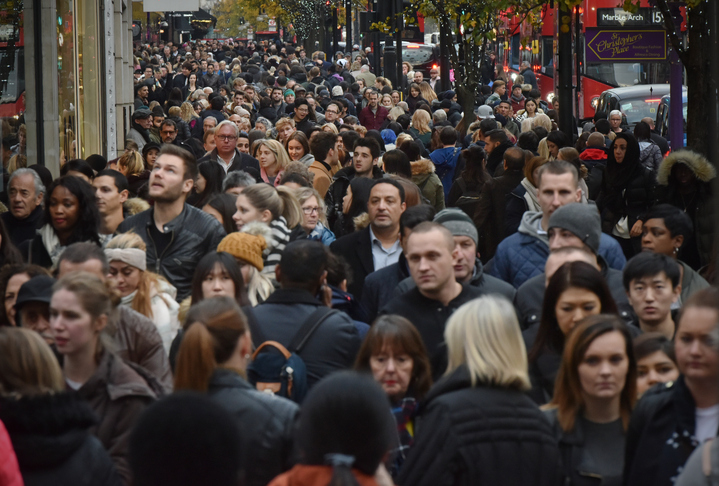 A huge crowd gathers on the street for Black Friday shopping.