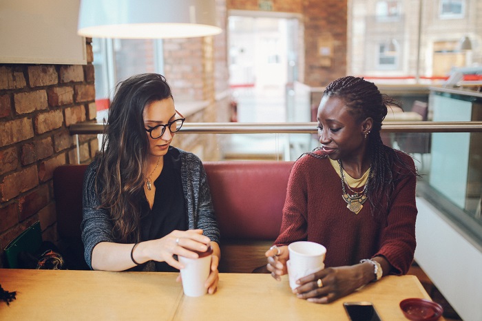 Two woman conversing over coffee in a cafe