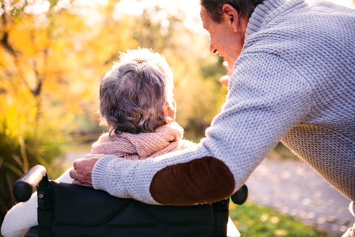 A husband and wife enjoy a sunny fall day.