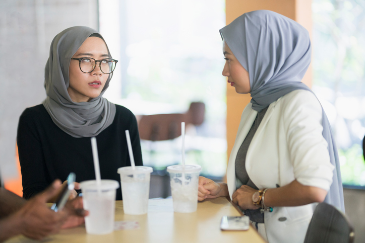 Two sisters bicker at the table.